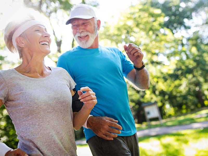 Well-aged man and woman showing happy endurance in exercising outdoors