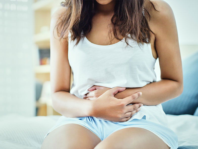 Woman holding her stomach because of abdominal pain