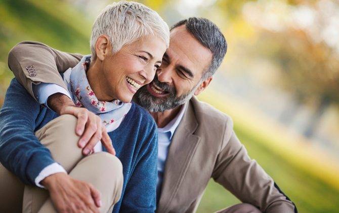 Vibrant looking, smiling middle aged couple hugging in the park Vibrant looking, smiling middle aged couple hugging in the park